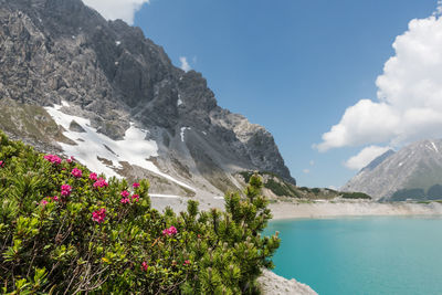 Scenic view of sea and mountains against sky