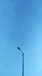 Low angle view of street light against blue sky