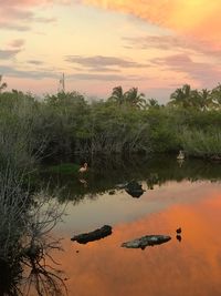 Scenic view of lake against sky at sunset