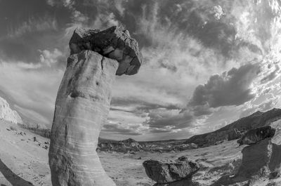 Rock formation against cloudy sky