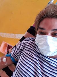 Portrait of man wearing mask donating blood