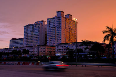 View of city street and buildings at dusk