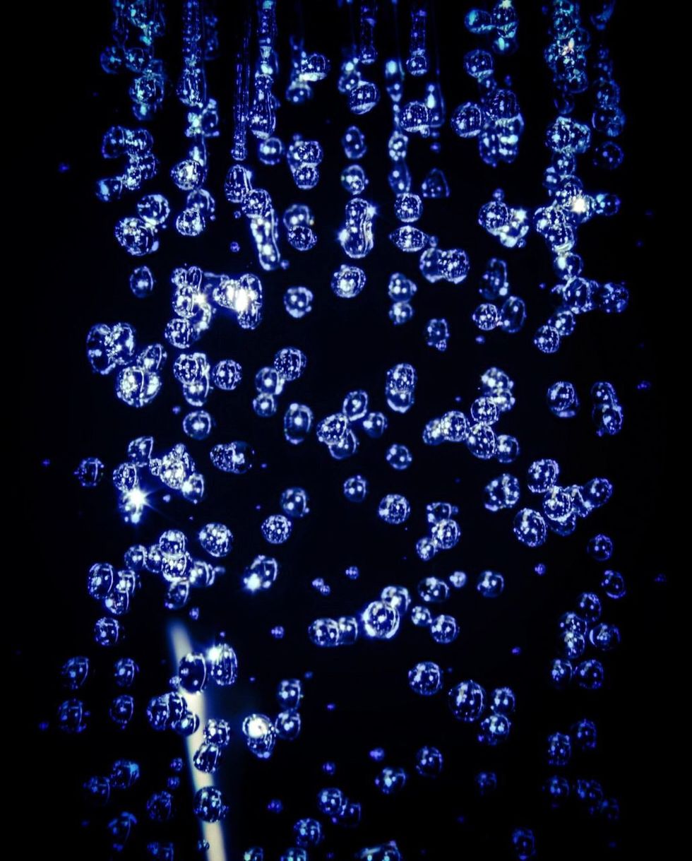 CLOSE-UP OF ILLUMINATED LIGHT AGAINST BLACK BACKGROUND