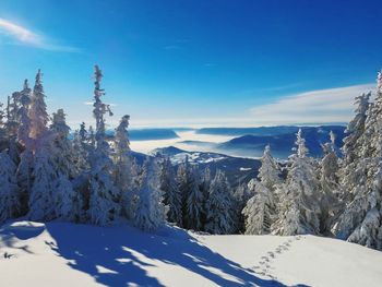 Scenic view of snow covered mountains against blue sky