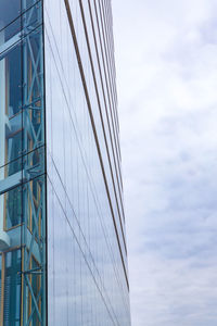 Low angle view of glass building against sky