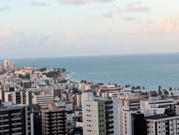 High angle view of buildings by sea against sky