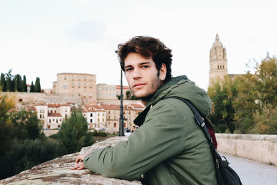 Portrait of young man standing against clear sky