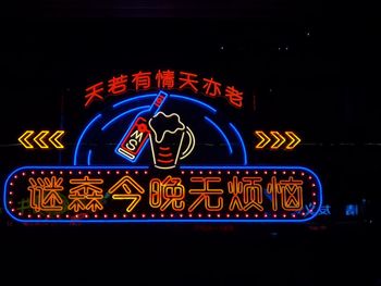 Low angle view of illuminated sign at night