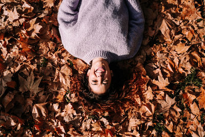 High angle view of teenage girl standing on dry leaves