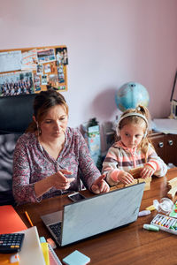 People looking at camera while sitting on table