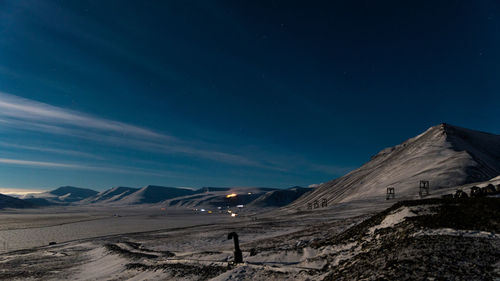 Scenic view of snowcapped mountains against sky at night