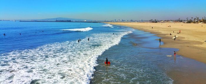 Panoramic view of people on beach against sky