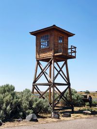 Lookout tower on land against clear blue sky