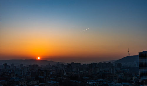 Aerial view of buildings against sky during sunset