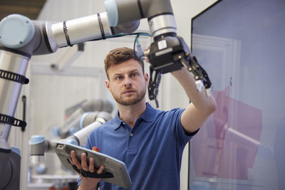 Focused engineer checking machine part holding equipment in industry