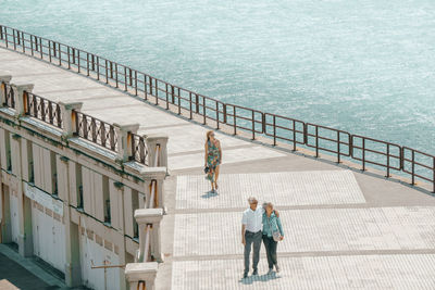 People standing on railing by water