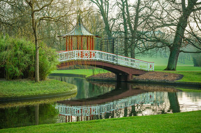 Park zone with river and bridge sorround by green grass field and trees, outdoor