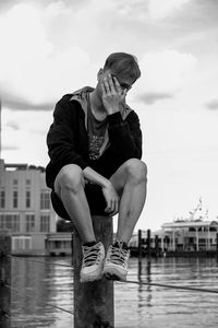 Full length of man sitting against sky