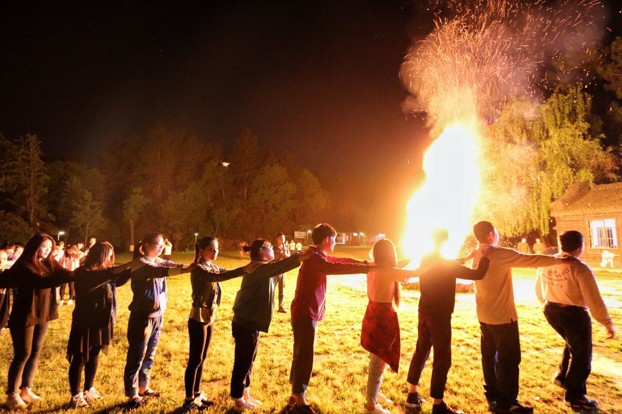 large group of people, men, lifestyles, night, person, illuminated, leisure activity, togetherness, flame, burning, celebration, crowd, fire - natural phenomenon, outdoors, mixed age range, standing, heat - temperature, arts culture and entertainment, enjoyment