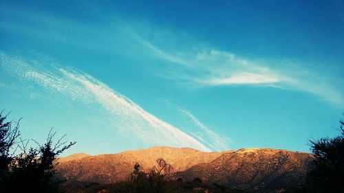 Scenic view of mountains against blue sky