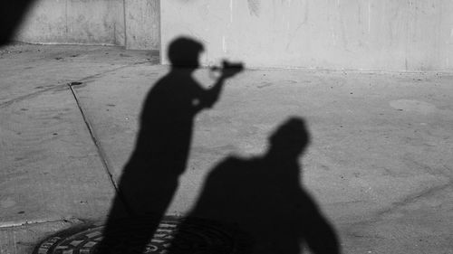 Shadow of man and woman standing on street