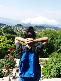 Rear view of woman standing against trees