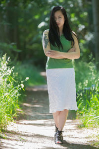 Young woman standing against plants