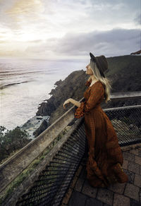 Rear view of woman looking at sea against sky