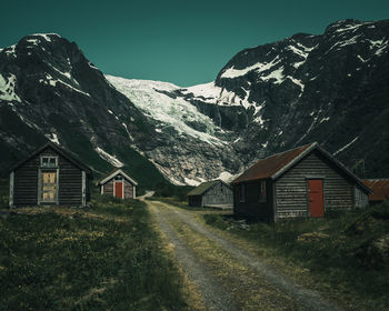 Houses on snowcapped mountains against sky