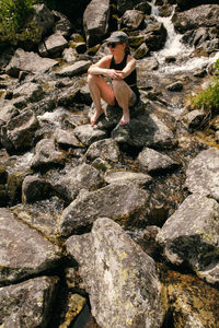 Woman sitting on rock