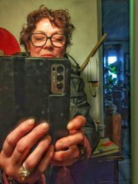 Portrait of woman using mobile phone at home