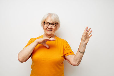 Portrait of woman with arms raised against white background