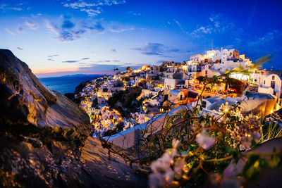 Illuminated houses against sky at dusk