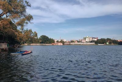 Scenic view of river against sky in city