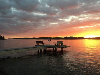 Pier over sea against sky during sunset