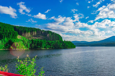 Scenic view of lake by mountain against sky