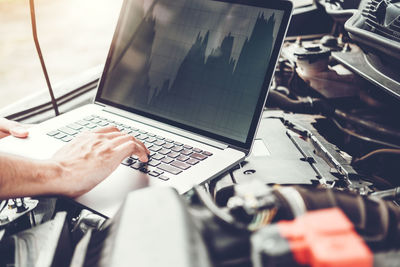 Midsection of man using laptop on table