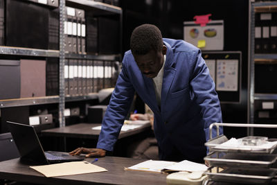 Side view of man working at table