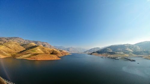 Scenic view of lake against clear blue sky