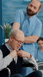 Male nurse examining senior man at clinic