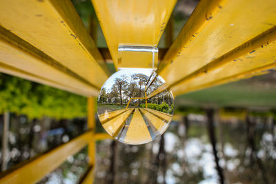 Upside down lensball view of the park, park seat in the reflection, bokeh background.