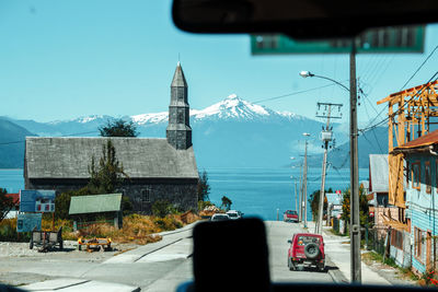 Buildings by road against sky in city