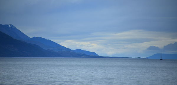 Scenic view of sea and mountains against sky