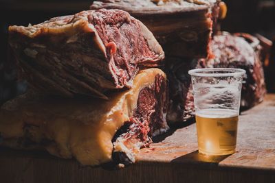 Close-up of meat and beer in glass on table