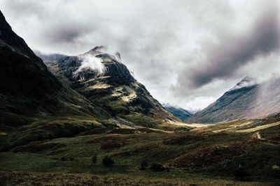 Scenic view of mountains against cloudy sky