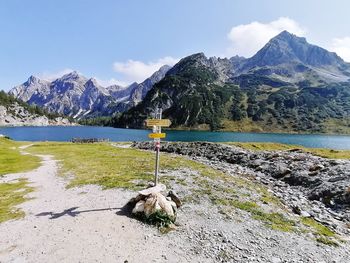 Scenic view of lake by mountains against sky
