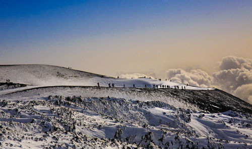 Tourist in winter landscape on etna volcano at sunset panoramic view of barbagallo crater