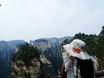 Panoramic view of people looking at mountain against sky