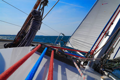 Sailboat sailing in sea against blue sky