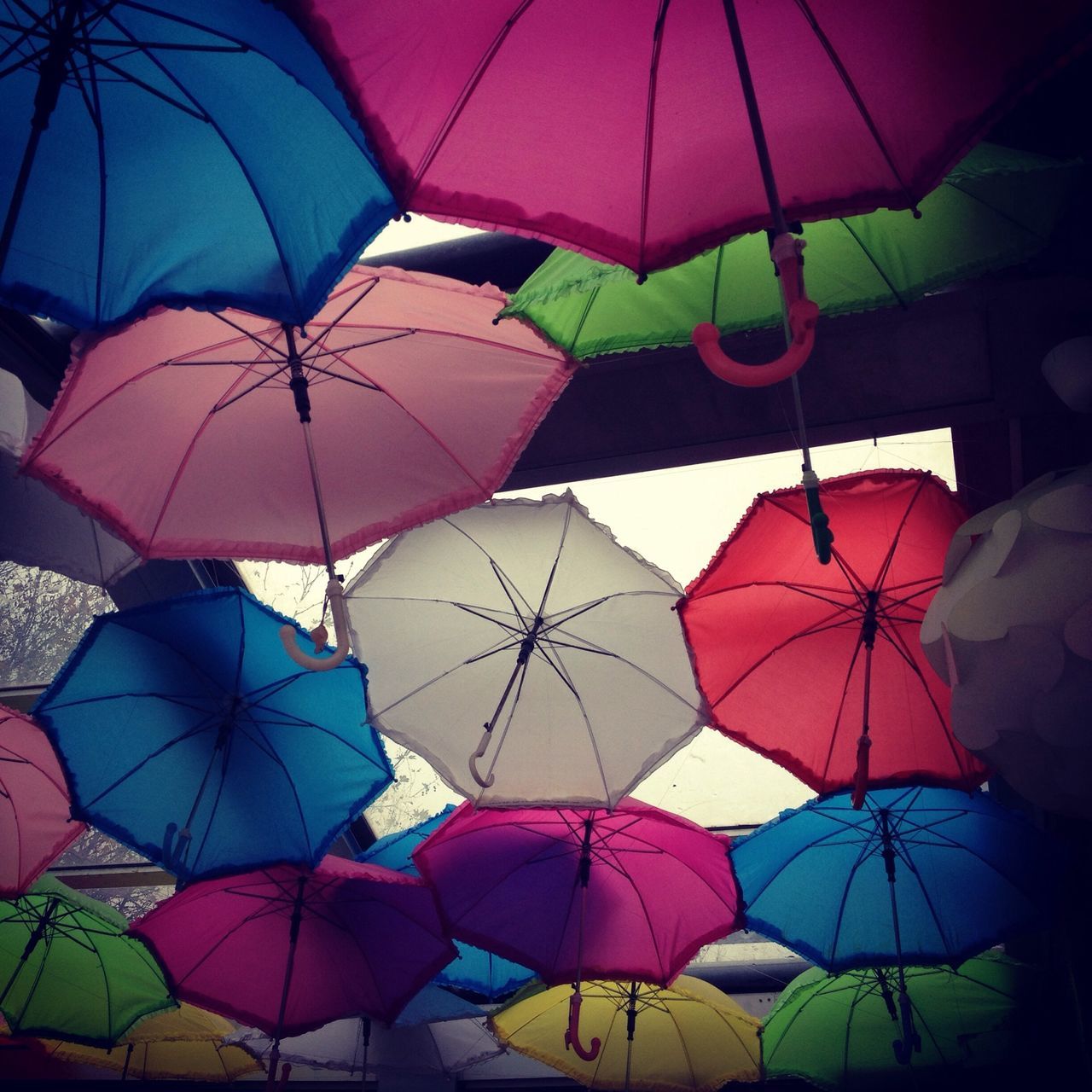 multi colored, abundance, in a row, umbrella, full frame, large group of objects, hanging, backgrounds, colorful, protection, pattern, low angle view, variation, decoration, side by side, no people, repetition, outdoors, shape, parasol